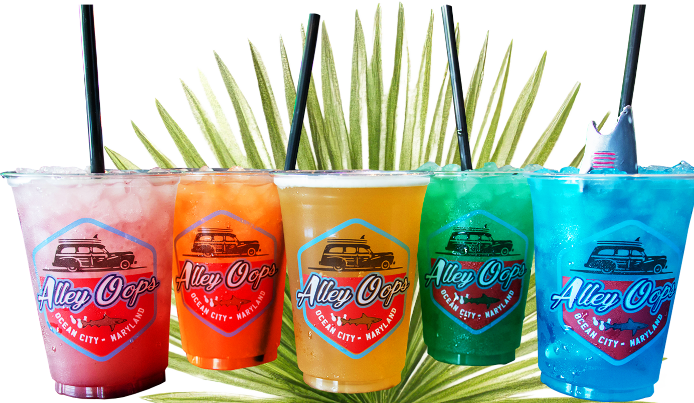 Five colorful drinks displayed alongside a palm leaf, showcasing vibrant hues and tropical ambiance.